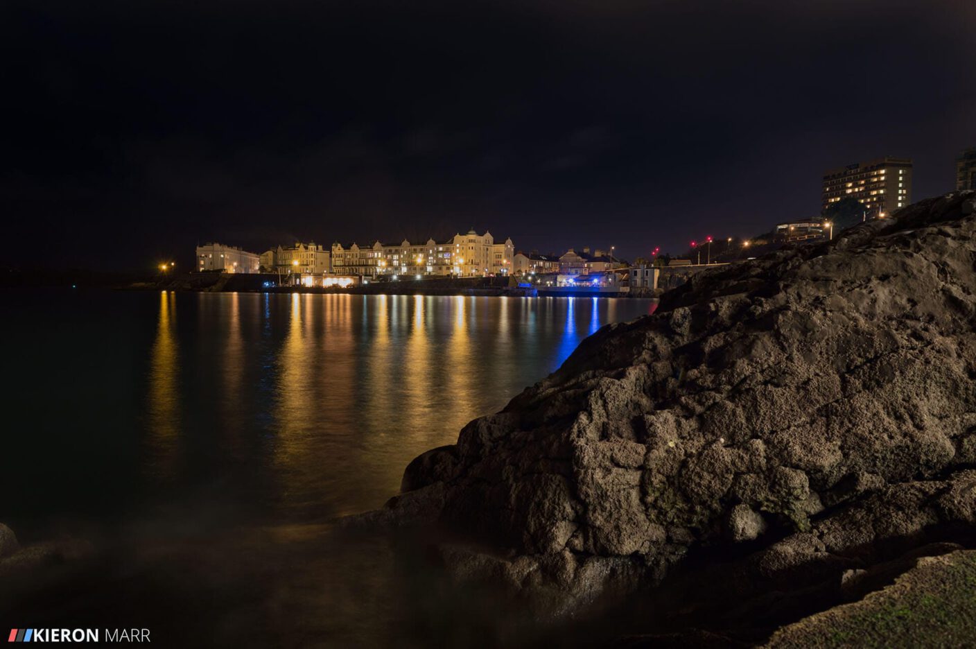 Plymouth Hoe at night with the lights reflecting off the water